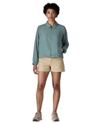 Woman wearing Patagonia women's lightweight jacket in blue. Features a full length front zip and side pockets. Jacket has a boxy fit and sits at the hips