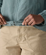 Close up of woman wearing Patagonia women's lightweight jacket in blue showing hands on the inside hem tie