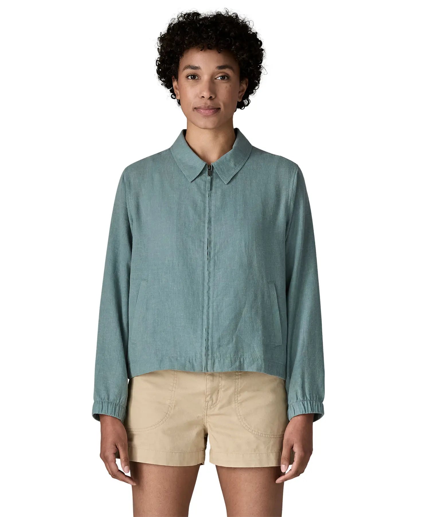 Woman wearing Patagonia women's lightweight jacket in blue. Features a full length front zip, collar and side pockets