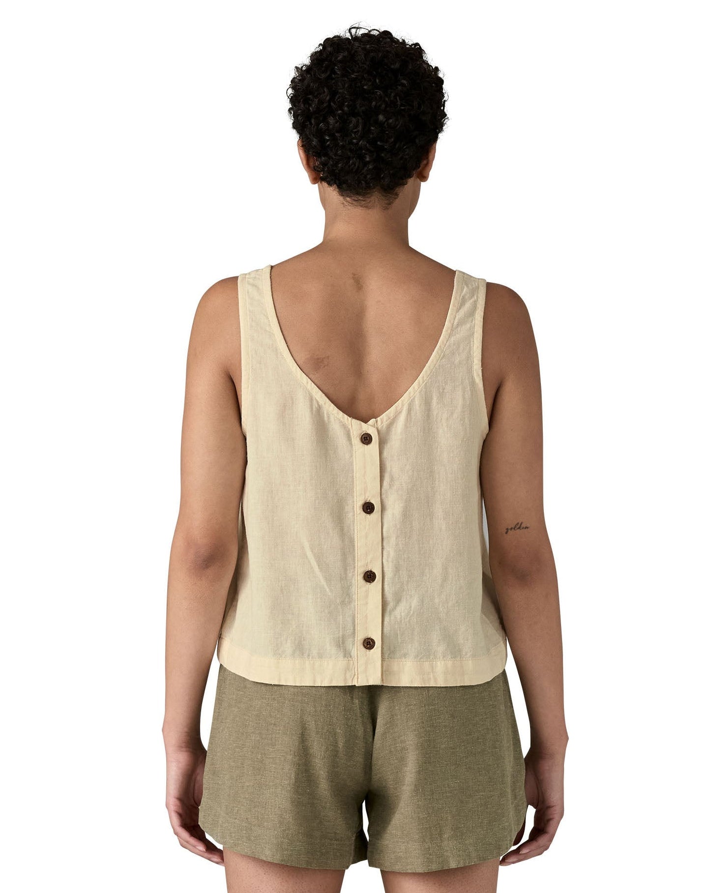 Woman wearing Patagonia women's reversible garden island vest top in cream showing full length back button fasteners