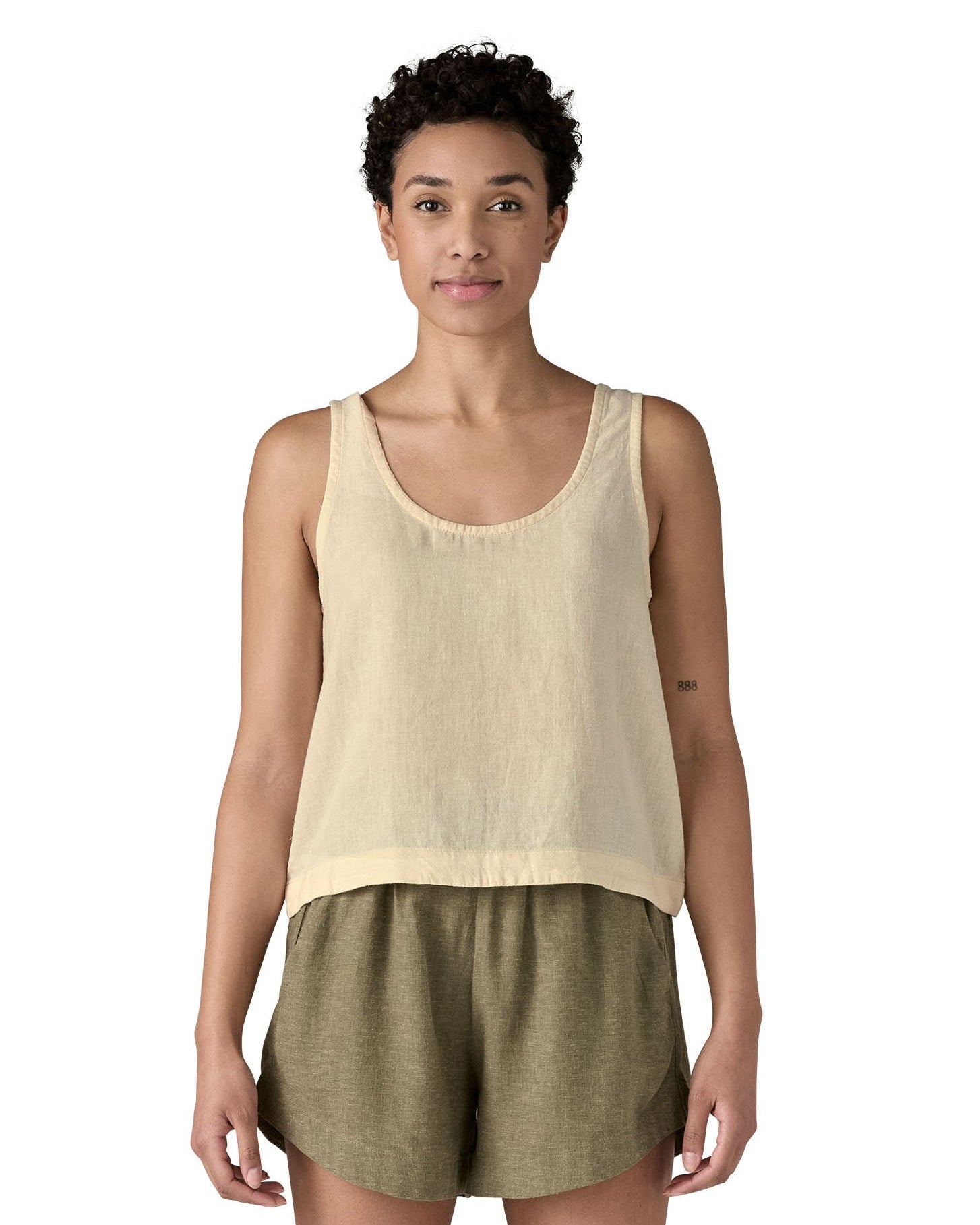Woman wearing Patagonia women's reversible garden island vest top in cream. Vest top has a relaxed fit