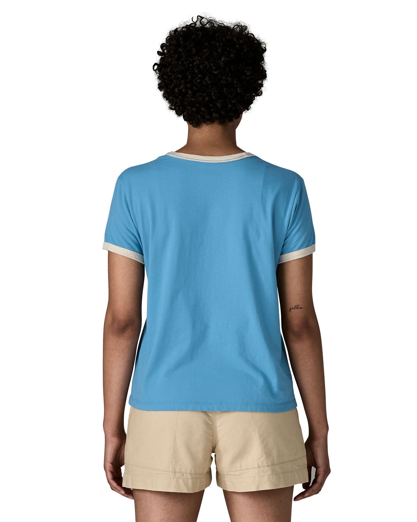 Back of woman wearing Patagonia women's great waves ringer t-shirt in light blue. Shows a white trim around the arms and collar