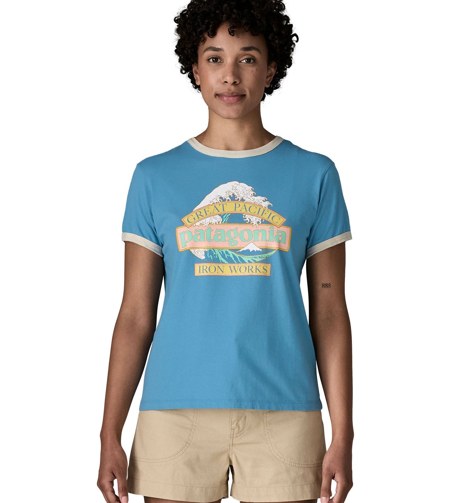 Woman wearing Patagonia women's great waves ringer t-shirt in light blue with a wave logo on the upper body.