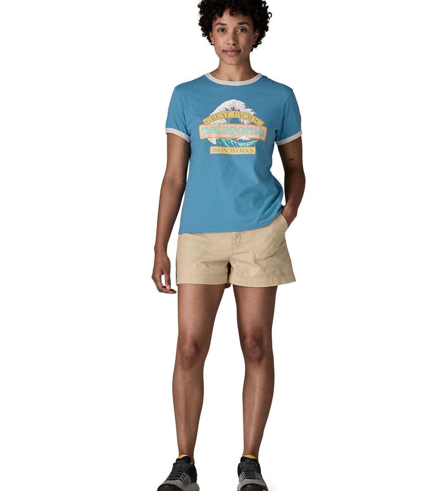 Woman wearing Patagonia women's great waves ringer t-shirt in light blue with a wave logo on the upper body. T-shirt has a regular fit