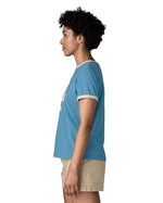Side of Woman wearing Patagonia women great waves ringer t-shirt in light blue. Showing a white trim around the arm and collar. 