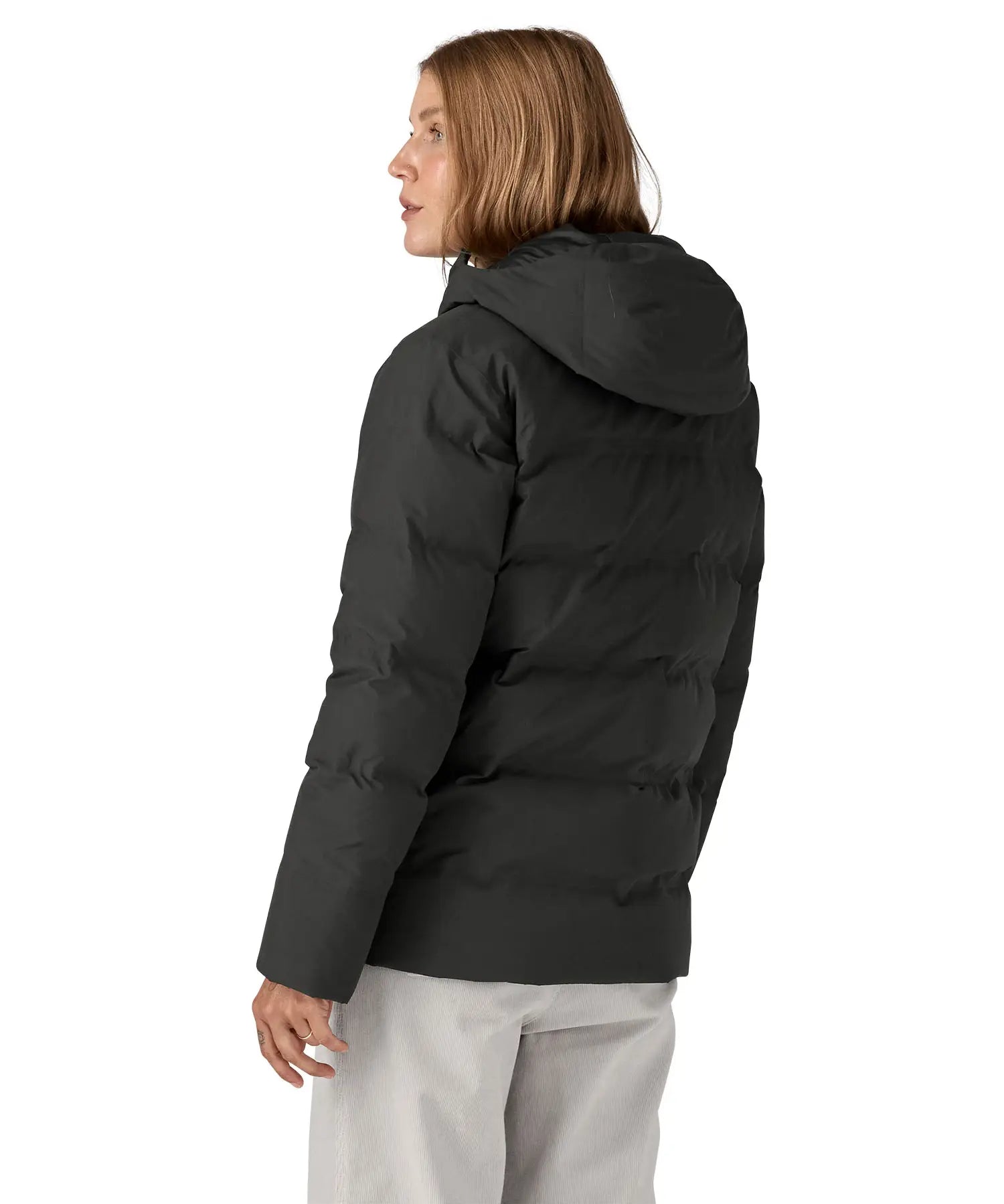 Back of woman wearing Patagonia's Jackson glacier hooded jacket in black. Jacket has a relaxed fit and sits at the hips