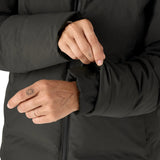 Woman pulling on the cuff on the Patagonia's waterproof Jackson glacier jacket in black showing the inner lining