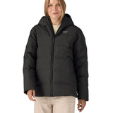 Woman wearing Patagonia's waterproof women's Jackson glacier hooded jacket in black. Jacket has a relaxed fit