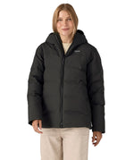 Woman wearing Patagonia's waterproof women's Jackson glacier hooded jacket in black. Jacket has a relaxed fit