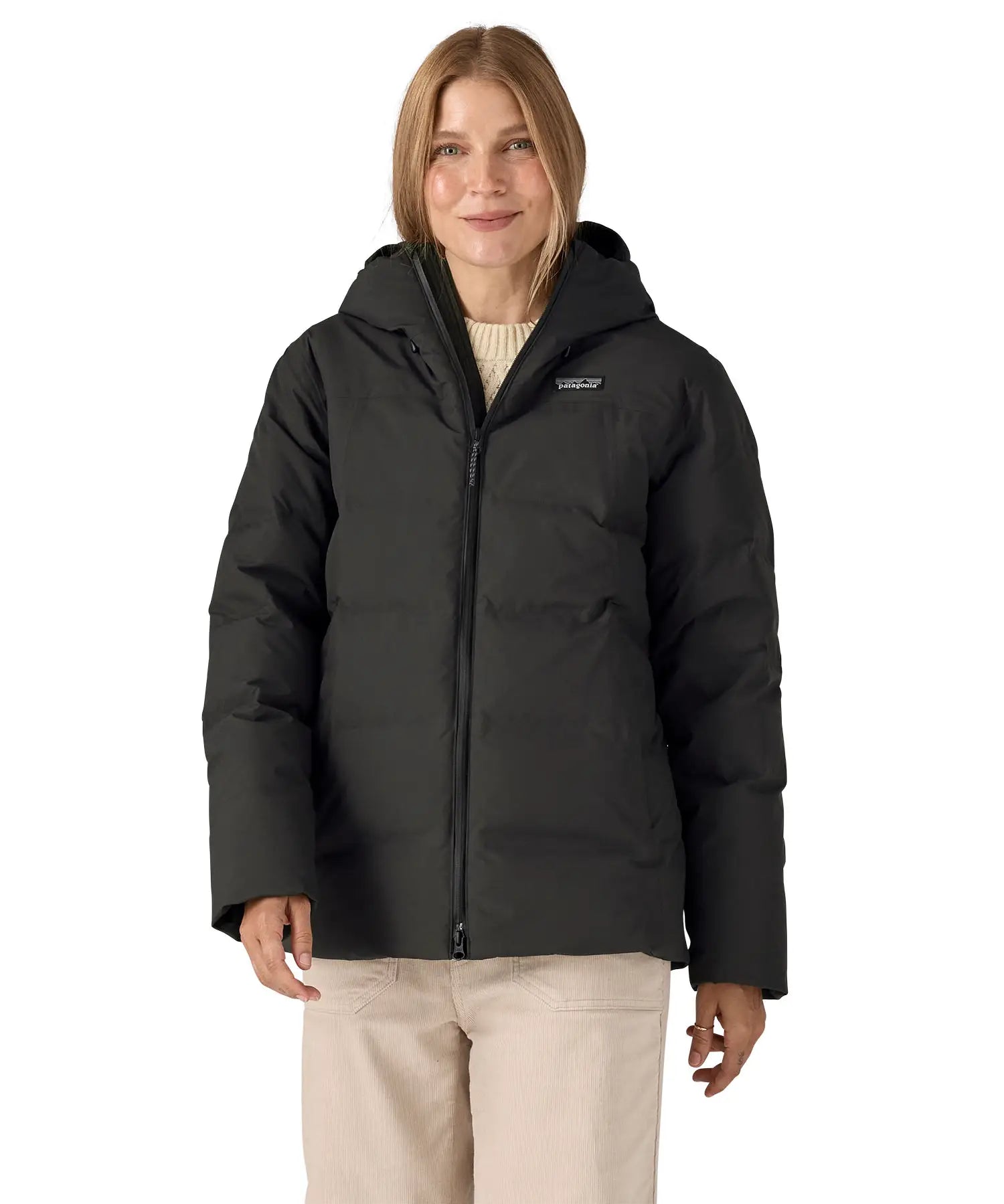 Woman wearing Patagonia's waterproof women's Jackson glacier hooded jacket in black. Jacket has a relaxed fit