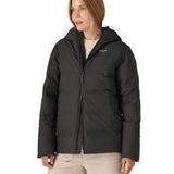 Woman wearing Patagonia's waterproof Jackson glacier hooded jacket in black showing front double zips opening the jacket