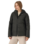 Woman wearing Patagonia's waterproof Jackson glacier hooded jacket in black showing front double zips opening the jacket