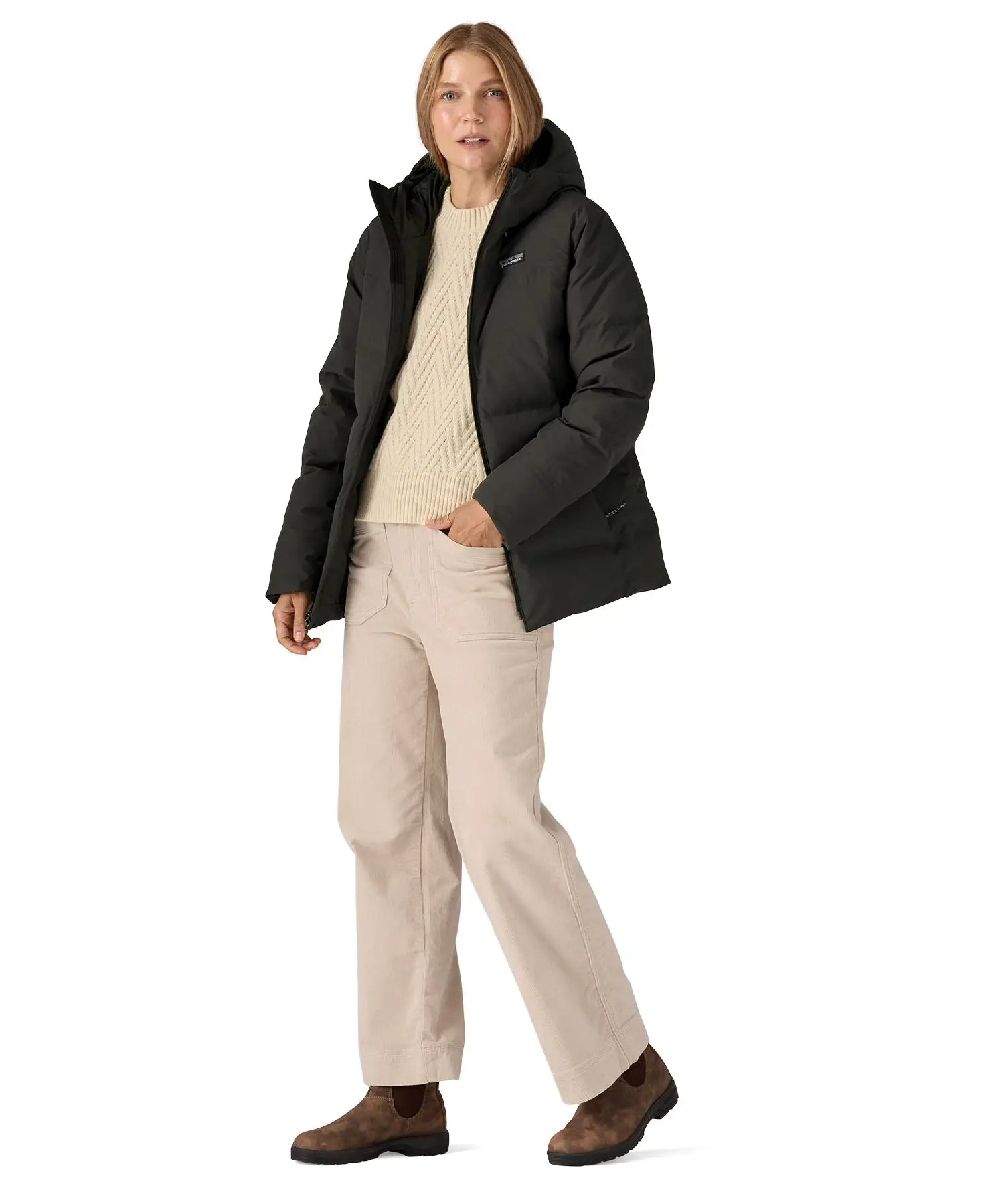 Woman wearing Patagonia's black waterproof Jackson glacier hooded jacket. Jacket has a relaxed fit and sits at the hips
