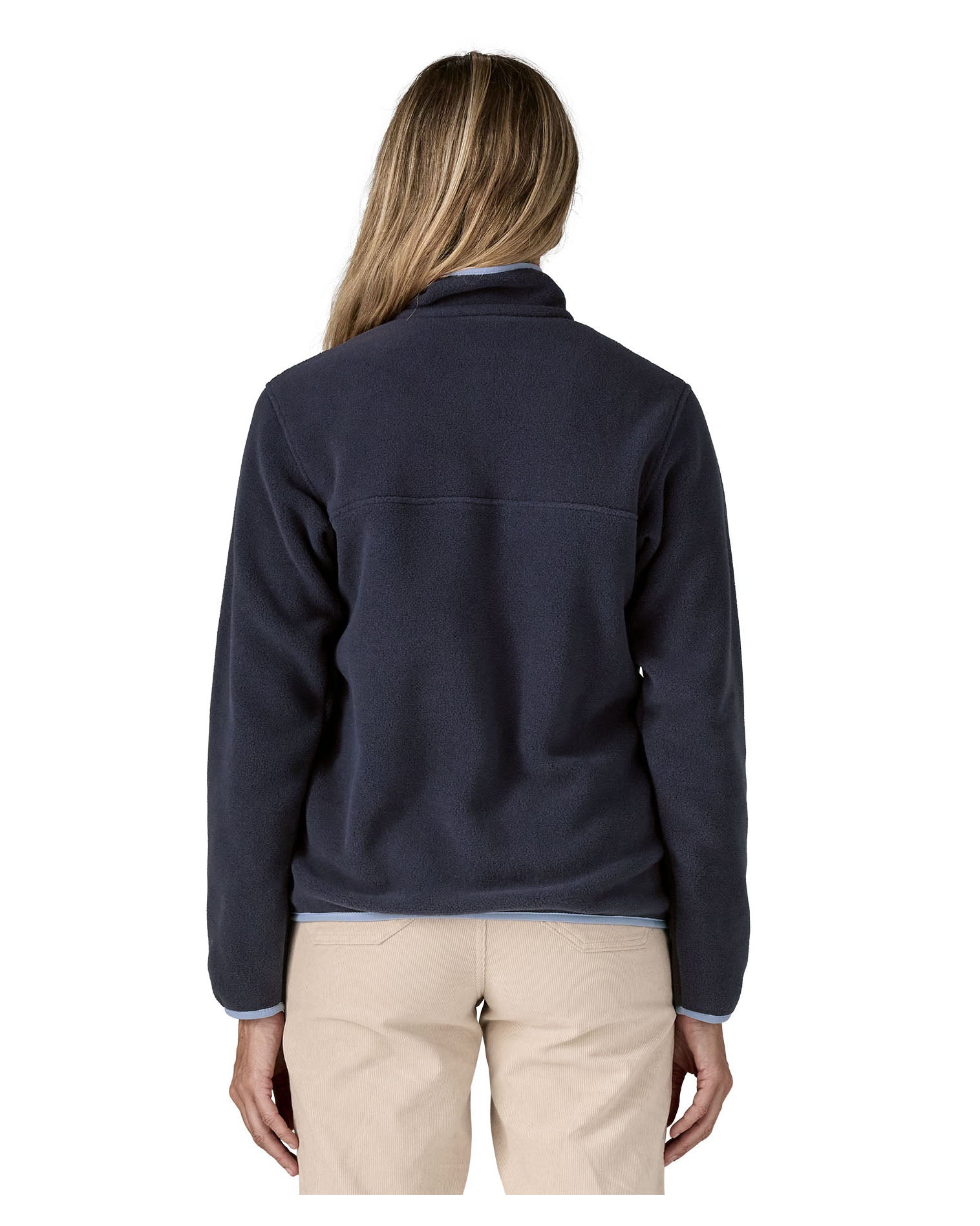 Back of a woman wearing Patagonia's synchilla snap t fleece in dark blue. Fleece has a relaxed fit and sits around the hips