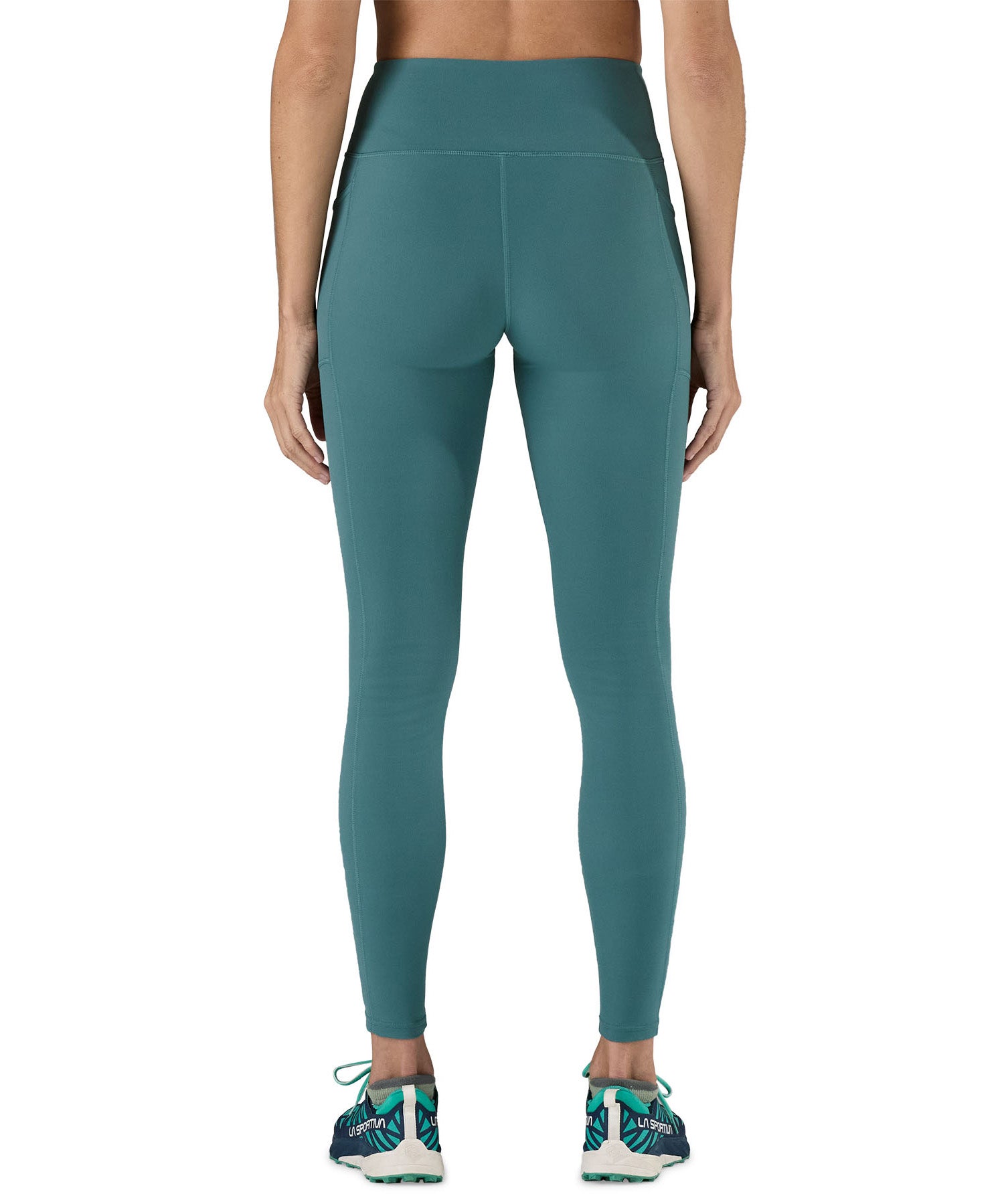 A model wearing the Patagonia women's leggings in wetland blue available at Babipur showing the back fit of the leggings