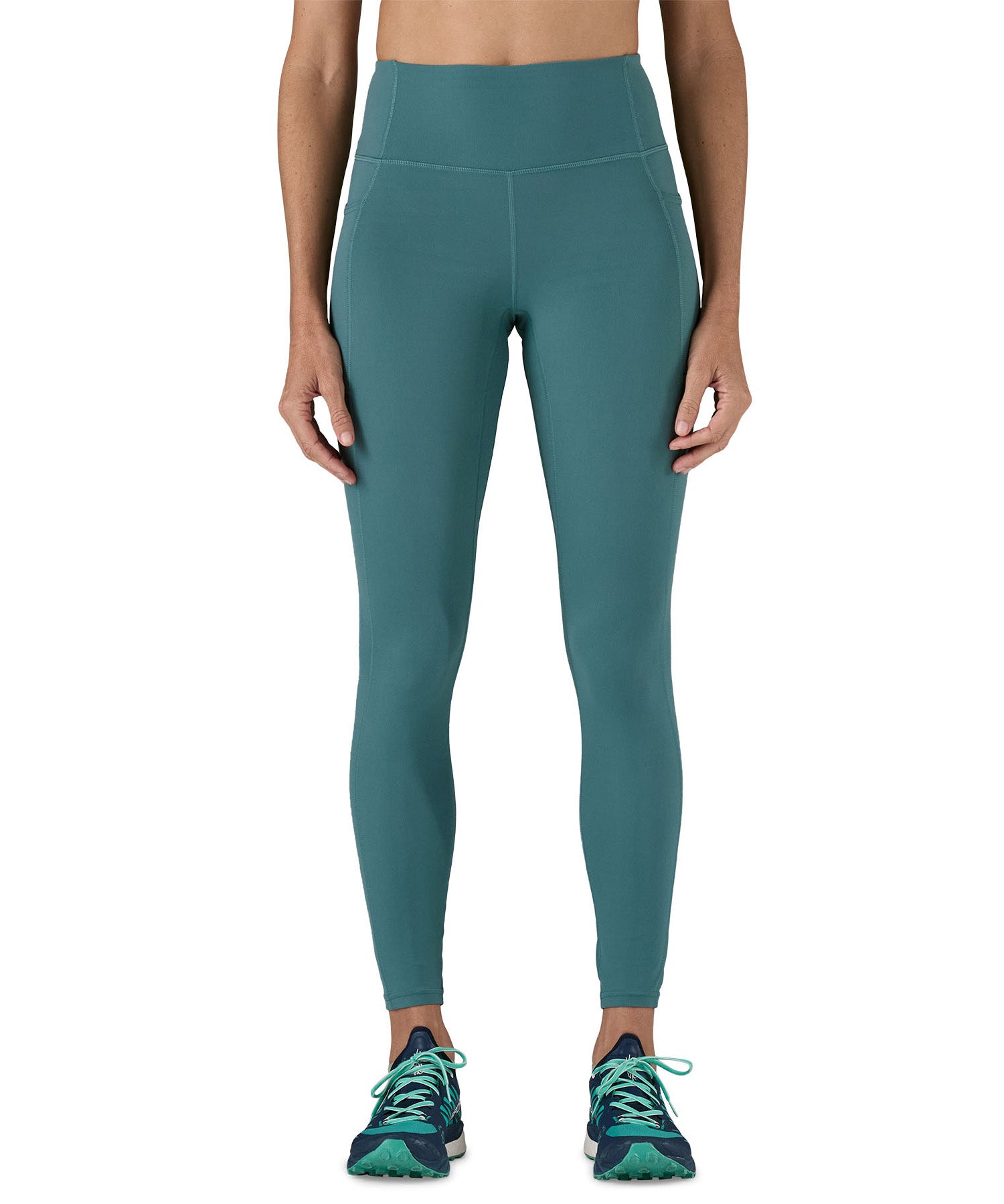 A model wearing the Patagonia women's leggings in wetland blue available at Babipur showing the front fit of the leggings
