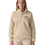 A woman wearing the Patagonia women's synchilla jacket in flow dyno white available at Babipur. A light cream flowing patterned fleece type jacket. Features the logo patch stitched on the left chest pocket, popper fasteners and a chest pocket. 