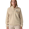 A woman wearing the Patagonia women's synchilla jacket in flow dyno white available at Babipur. A light cream flowing patterned fleece type jacket. Features the logo patch stitched on the left chest pocket, popper fasteners and a chest pocket. 