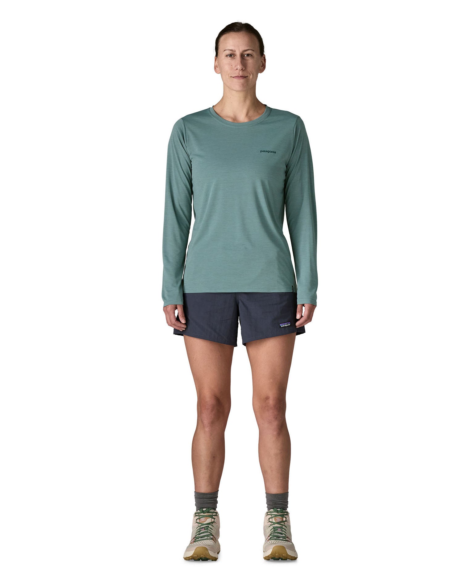 Woman wearing Patagonia's women's long sleeve capilene cool t-shirt in sage blue. T-shirt has a relaxed fit and sits at the hips