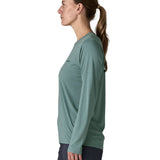 Side of woman wearing Patagonia's women's long sleeve capilene cool t-shirt in sage blue. T-shirt has a relaxed fit and sits at the hips