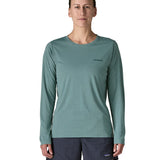 Woman wearing Patagonia's women's long sleeve capilene cool t-shirt in sage blue with small brand text on chest