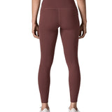 Back of woman wearing Patagonia's maipo stash leggings in dark red. Tights have a high rise fit 