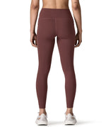 Back of woman wearing Patagonia's maipo stash leggings in dark red. Tights have a high rise fit 