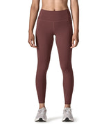 Woman wearing Patagonia's maipo stash leggings in dark red. Tights have a high rise fit 