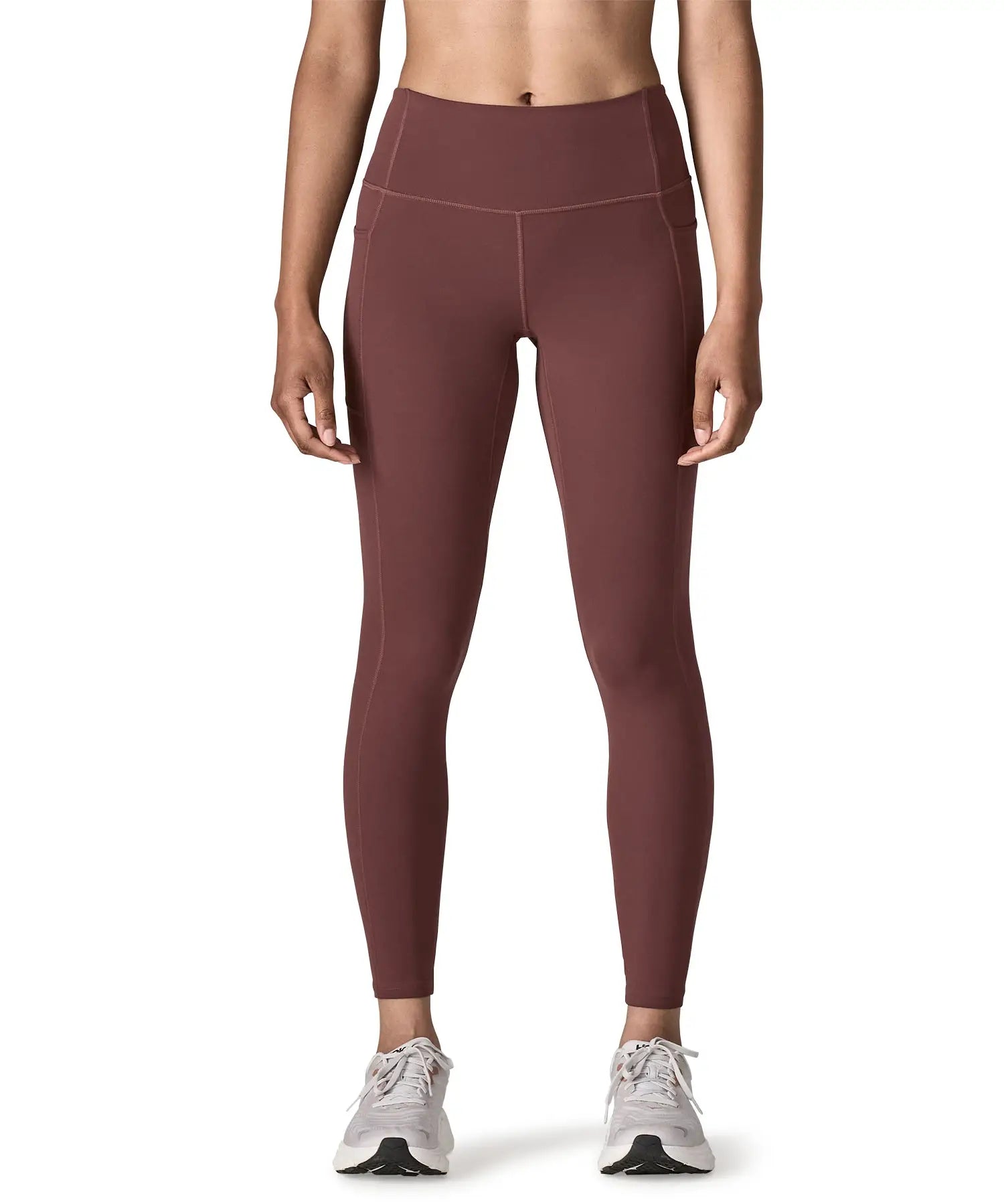 Woman wearing Patagonia's maipo stash leggings in dark red. Tights have a high rise fit 