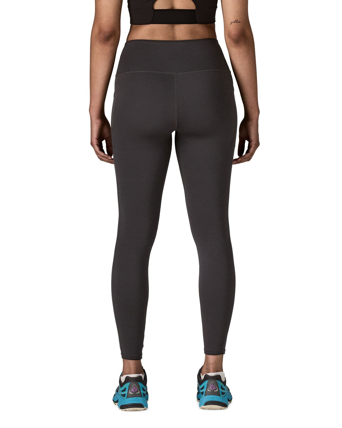 Back of woman wearing Patagonia's maipo stash black leggings. Tights have a high rise fit and 7/8 length