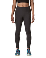 Woman wearing Patagonia's maipo stash black leggings. Tights have a high rise fit 