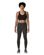 Woman wearing Patagonia's maipo stash black leggings with a black sports vest and trainers