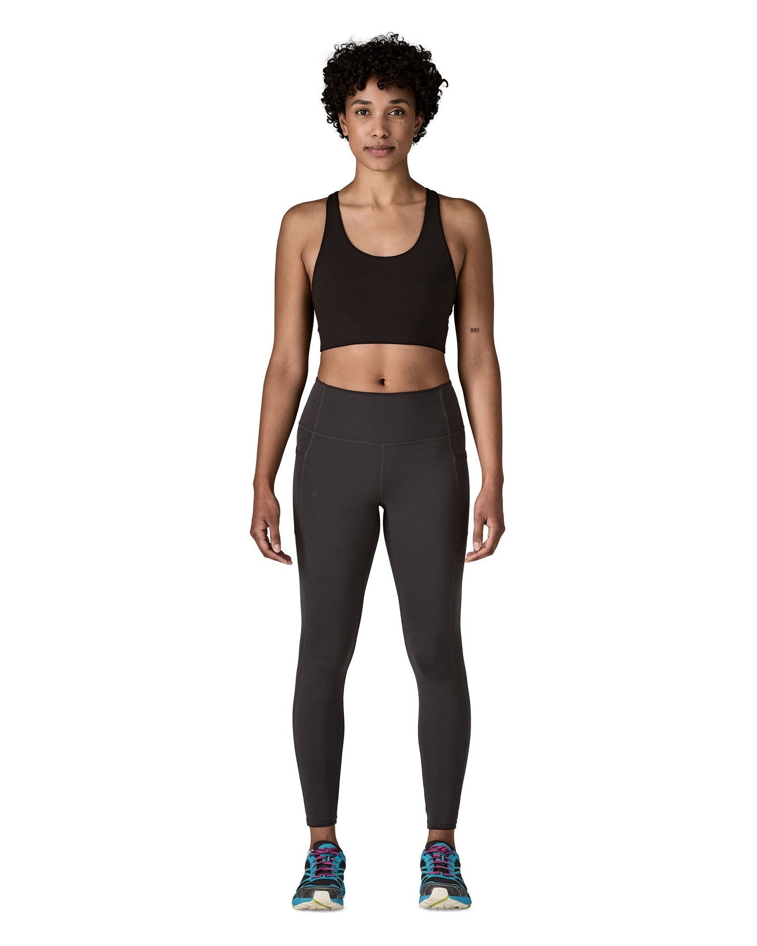 Woman wearing Patagonia's maipo stash black leggings with a black sports vest and trainers