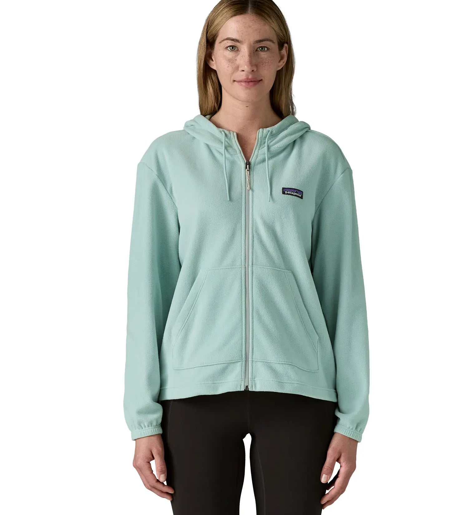 Woman wearing Patagonia's micro d hooded fleece in virtually blue. Fleece has a relaxed fit and sits at the hips