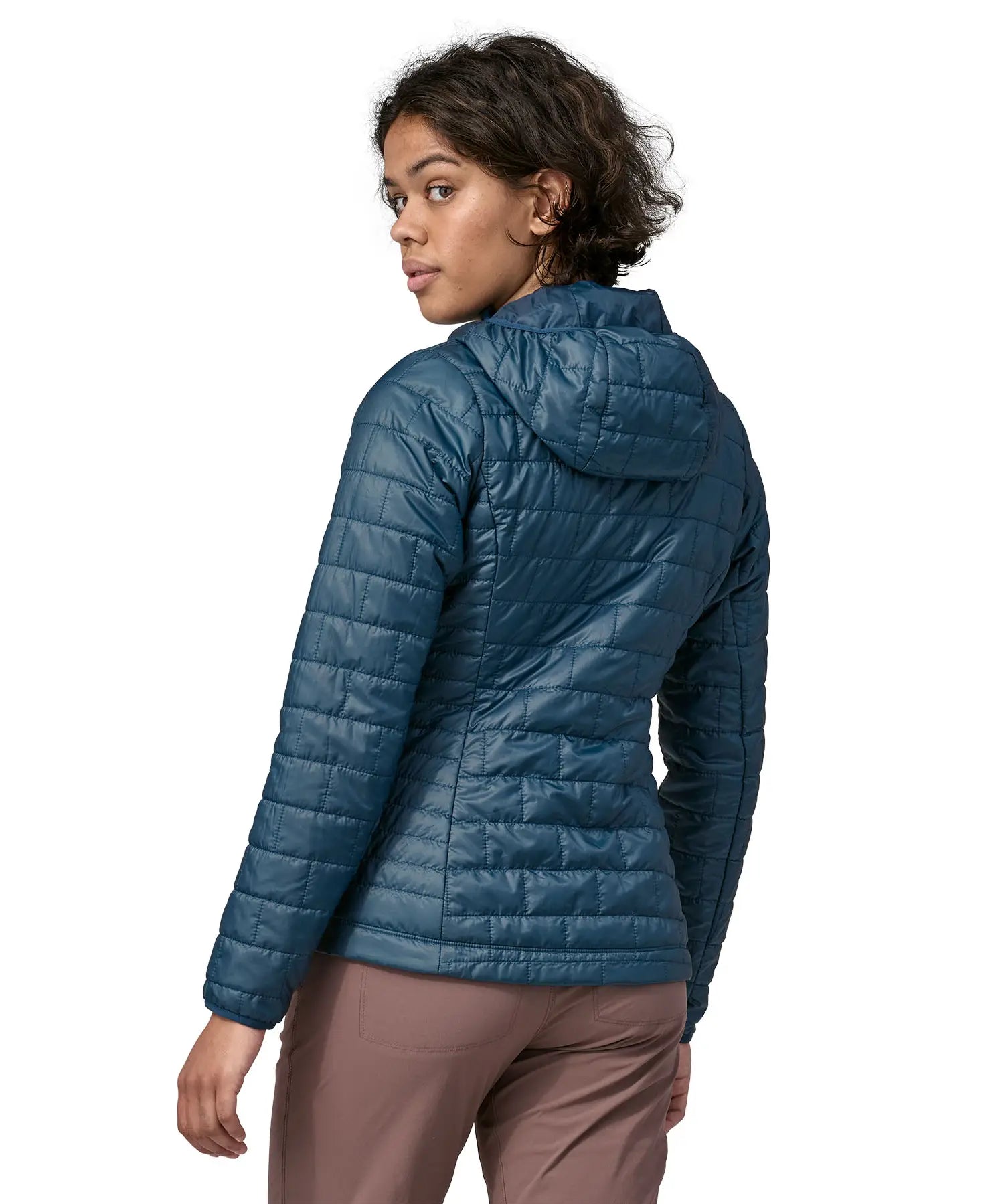 Back of Woman wearing the Patagonia nano puff hoody jacket in a lagom blue. Jacket has a regular fit and sits around the hips