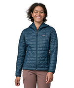 Woman wearing the Patagonia nano puff hoody jacket in a lagom blue. 