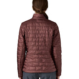A female model wearing the Patagonia women's nano puff jacket in dark ruby showing the back fit of the jacket
