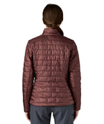 A female model wearing the Patagonia women's nano puff jacket in dark ruby showing the back fit of the jacket