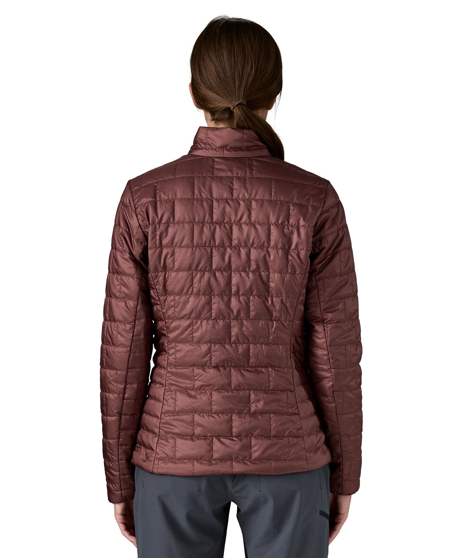 A female model wearing the Patagonia women's nano puff jacket in dark ruby showing the back fit of the jacket