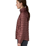 The side of the Patagonia women's nano puff jacket in dark ruby. Jacket is worn by a female model and showing the arm fit of the jacket