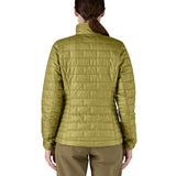 A female model wearing the Patagonia women's nano puff jacket in graze green showing the back fit of the jacket