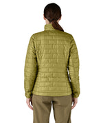 A female model wearing the Patagonia women's nano puff jacket in graze green showing the back fit of the jacket