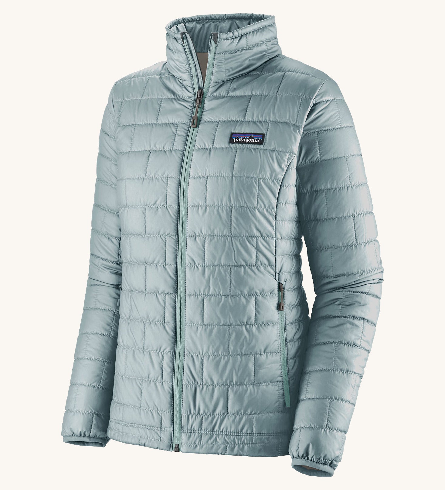 The front of the Patagonia women's nano puff jacket in thermal blue. A light blue jacket with rectangular puffer panels. Jacket features a full length zip and side pockets