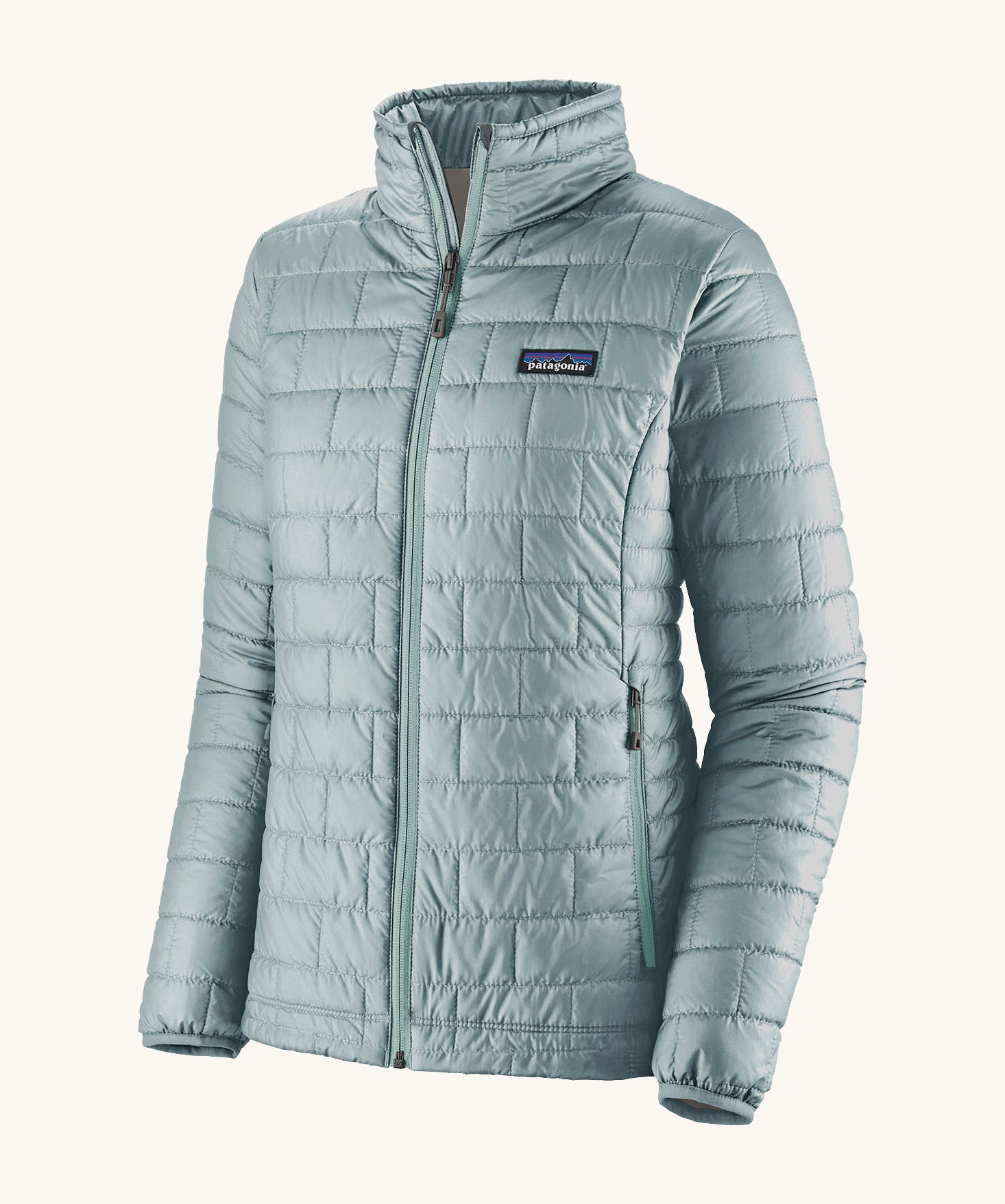 The front of the Patagonia women's nano puff jacket in thermal blue. A light blue jacket with rectangular puffer panels. Jacket features a full length zip and side pockets