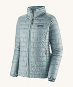 The front of the Patagonia women's nano puff jacket in thermal blue. A light blue jacket with rectangular puffer panels. Jacket features a full length zip and side pockets