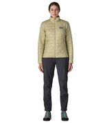 Woman wearing Patagonia nano puff jacket in weathered stone. Jacket has a regular fit