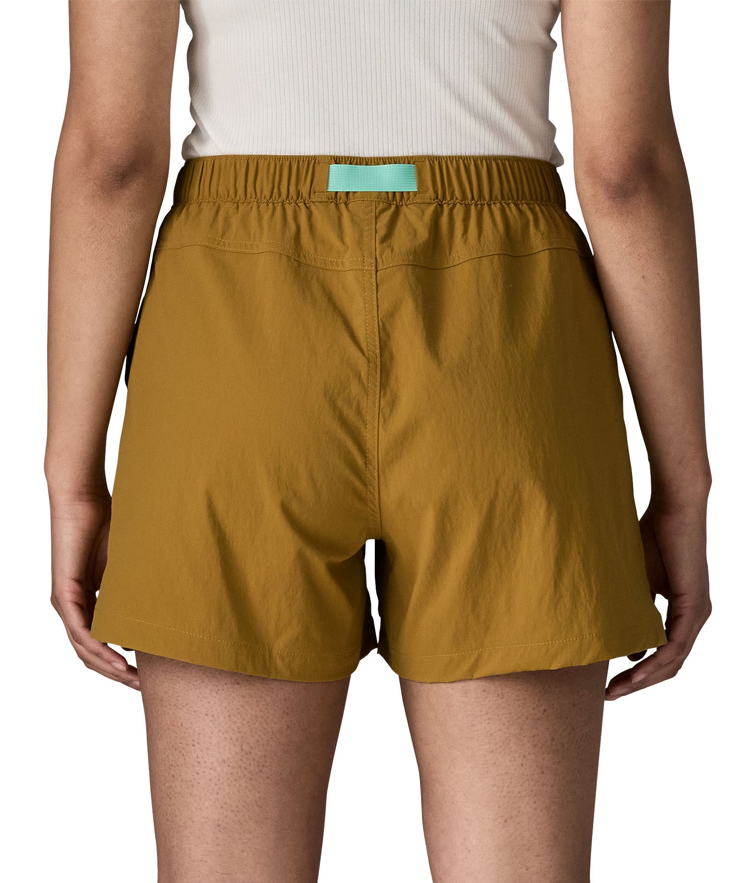Back of woman wearing Patagonia's women's outdoor everyday shorts in brown. Shorts have a loose fit and sit above the knees