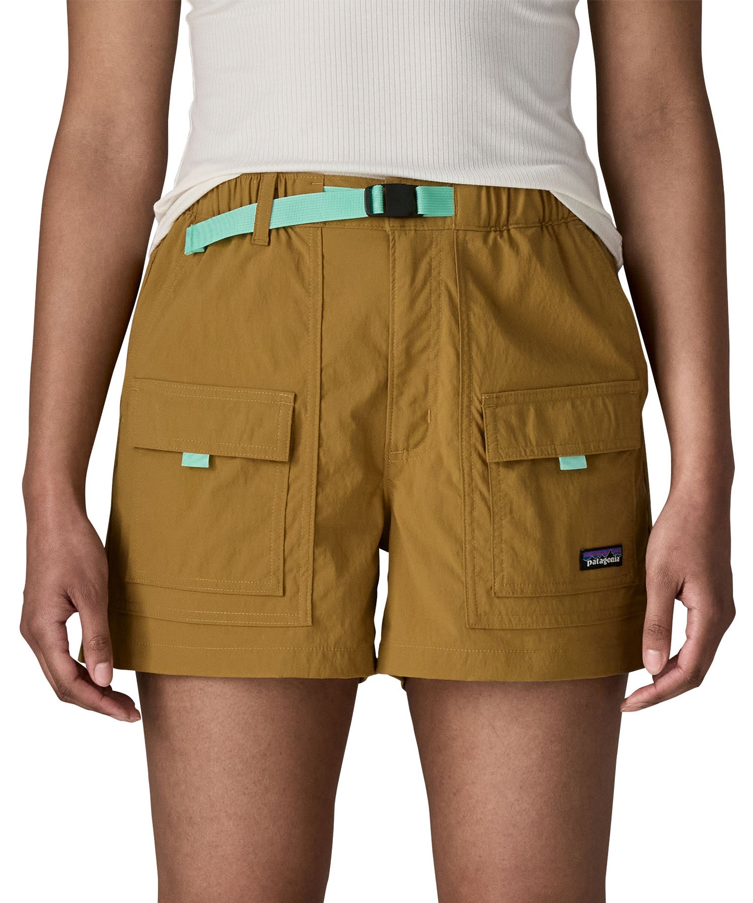 Woman wearing Patagonia's women's outdoor everyday shorts in brown. Shows front pockets. Shorts have a loose fit
