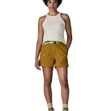 Woman wearing Patagonia's women's outdoor everyday shorts in brown with hand in side pocket. Shorts have a loose fit and sit over the knees