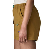 Side of woman wearing Patagonia's women's outdoor everyday shorts in brown. Shows front panel pockets.